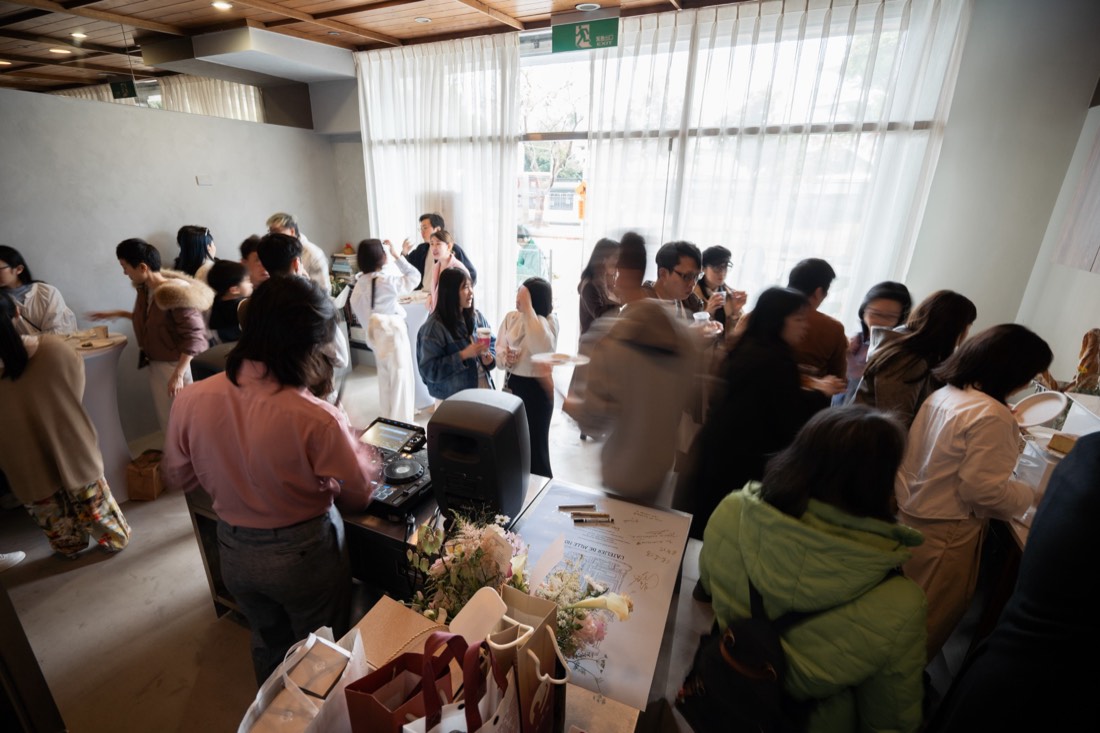 擠滿來賓的店內，窗邊透著自然光